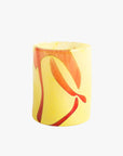 A handblown yellow glass tumbler with red swirl patterns.