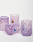 A set of hand-blown Murano shot glasses with a purple color and murrina details.