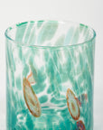 A hand-blown, multicolored Murano glass tumbler with a tapered shape, featuring green, white, and brown swirls.