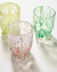 Three textured glass tumblers with organic splatter patterns in pale yellow-green, mint green, and blush pink, arranged on a white surface with soft shadows.