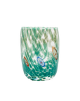 A hand-blown glass tumbler with a green and teal water ripple pattern, featuring small decorative medallions in blue, brown, and white.