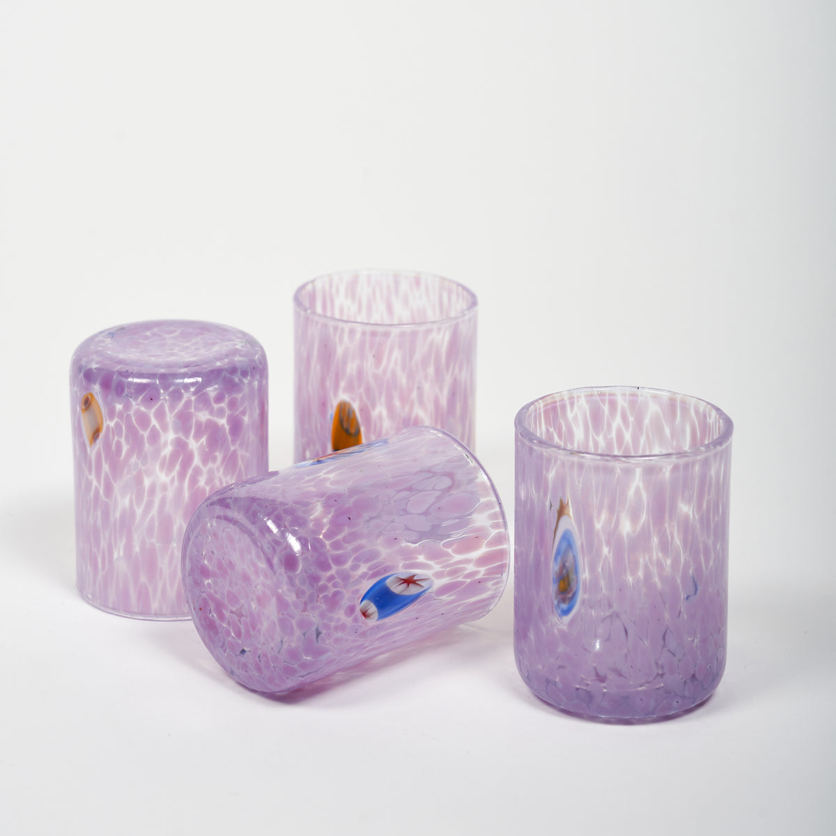 A set of hand-blown Murano shot glasses with a purple color and murrina details.