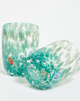 Two Murano glass tumblers with a speckled green pattern and multicolored accents.