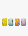 A set of four hand-blown multicolored glass shot glasses, each with unique patterns and designs.
